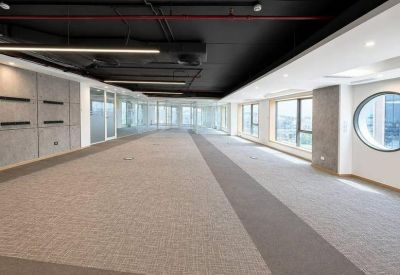 Long open-plan office area with large windows providing ample natural light.
