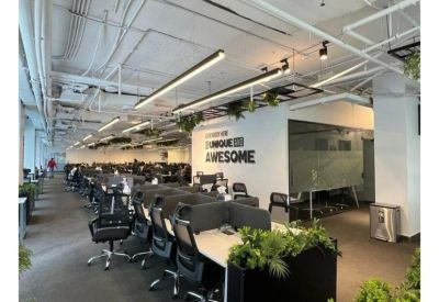 Bright office space featuring a motivational wall mural and potted plants.
