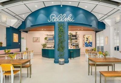 Stylish coffee shop counter with teal archway and 'Stellski' neon signage.
