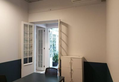 Interior doorway leading to a bright white office area with storage lockers.