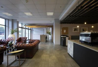 Lounge area with tufted leather sofas and a coffee bar in the background.