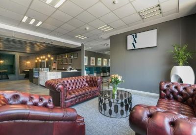 Lounge area with plush burgundy chesterfield sofas and a modern coffee table.