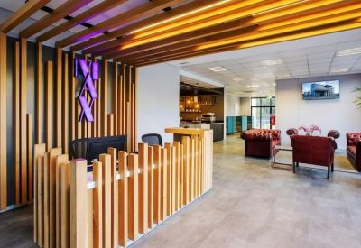 Reception area featuring a unique wooden slat desk design and warm overhead lighting.