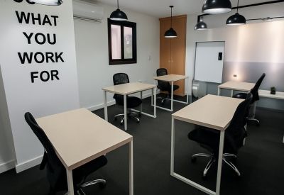 Modern coworking area with black pendant lights and motivational wall text.