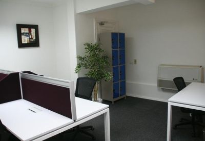 Private office workspace featuring white desks with privacy dividers and a blue storage locker.