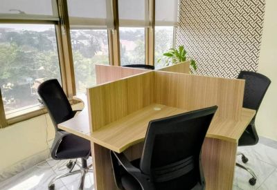 Four-person wooden workstation pod with privacy dividers and ergonomic chairs.