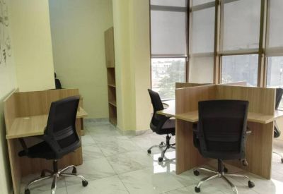 Bright coworking area with individual desks and grey tile flooring.
