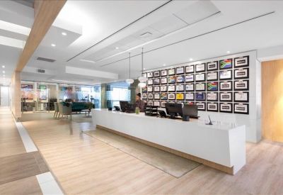 Professional reception area with a long white desk and a wall of framed certificates.