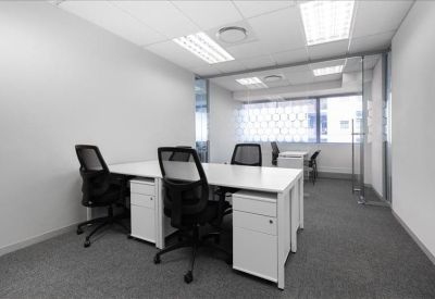 Clean, white four-person private office suite with glass partitions.