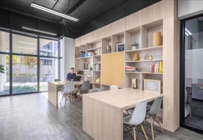 Bright coworking area featuring light wood shelving and a large window.