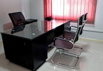 Private office suite featuring a dark glass-top desk and red vertical blinds.