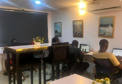 Modern coworking space with high-top tables, bar stools, and framed wall art.