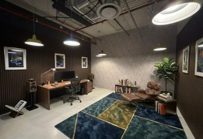 Office lounge area with plush seating, patterned rug, and wall art.