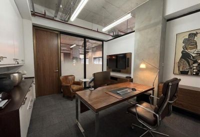 Private executive office with a wooden desk and glass partitions.
