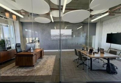 Large meeting room separated by glass walls from an open workspace.
