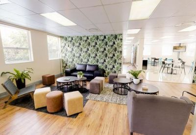 Modern breakout lounge featuring a botanical wallpaper and colourful seating.