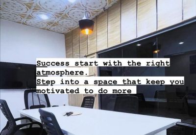 Bright conference room with a large white table, ergonomic chairs, and a decorative patterned ceiling.