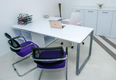 Private office suite with a white desk, purple chairs, and a storage cabinet.