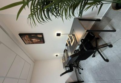 Close-up of a professional desk setup with mesh task chairs and warm wall lighting.