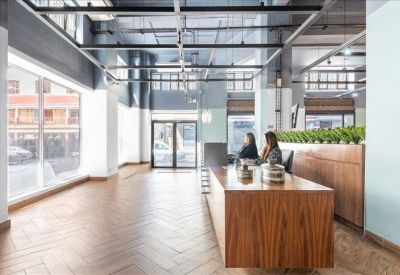 Bright lobby area with a wooden reception desk and indoor greenery.