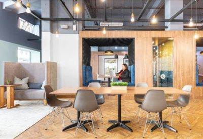 Open-plan coworking space with private alcoves and modern workstations.