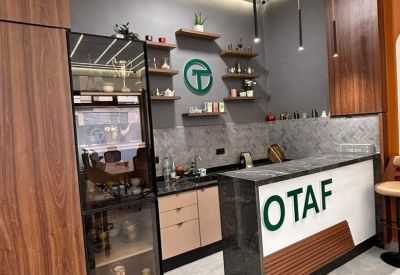 Office kitchen and reception area with a branded 'OTAF' marble counter and wood accents.