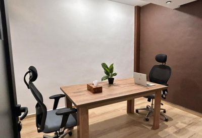 Private office suite with a wooden desk and two modern mesh chairs.