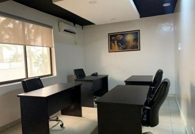 Private office space with natural light from a window and three professional workstations.