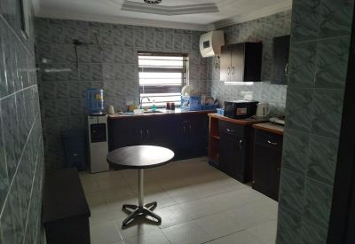 Communal kitchen area with dark cabinetry and a small round bistro table.