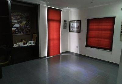 Meeting room with sleek grey flooring, red window blinds, and built-in shelving.