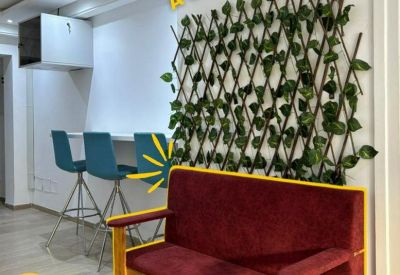 Reception area featuring a maroon velvet bench and a decorative green wall trellis.