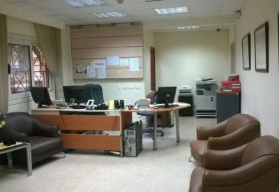 Spacious reception area with leather armchairs and a wooden front desk.