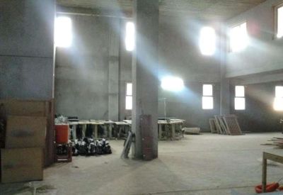Spacious unfinished industrial interior with tall concrete columns and natural light streaming through windows.