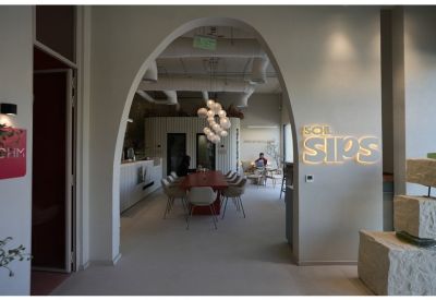 Arched entrance leading to a bright reception area with a Soil Sips branded sign on the wall.