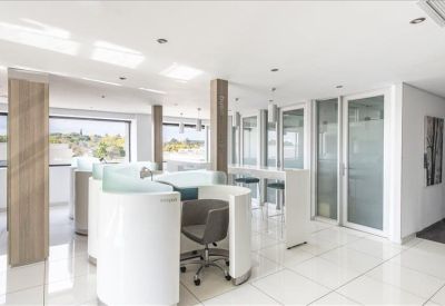 Sleek co-working area with white circular privacy pods and bright natural light.
