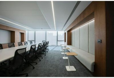 Long meeting room featuring a white boardroom table and built-in wooden wall niches.