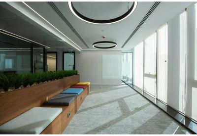 Vibrant breakout area with wooden planters, colorful seating, and large windows for natural light.