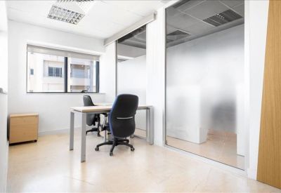 Bright private office suite with two desks and frosted glass partitions.