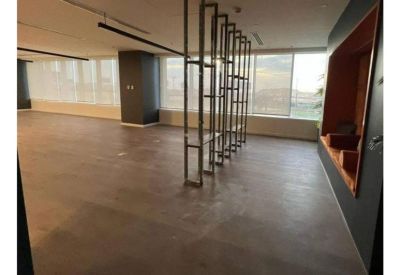 Spacious open-plan communal area with wood flooring and a decorative metal room divider.
