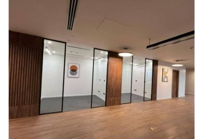 Private office suites featuring glass partitions and natural wood accents.