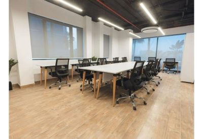 Spacious open-plan workspace with multiple desks and large windows.