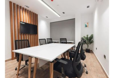 Modern meeting room featuring a wooden slat accent wall and wall-mounted TV.