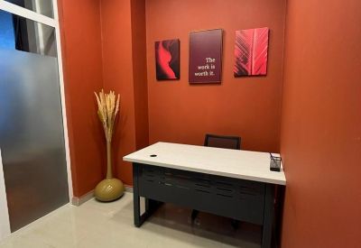 Private office with a white desk against warm terracotta walls and inspirational artwork.