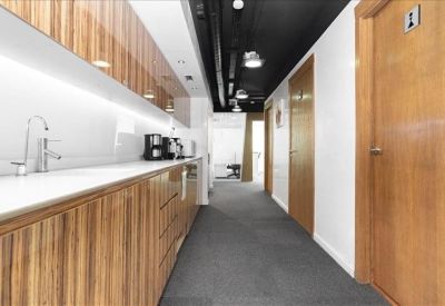 Hallway with a long wooden kitchen counter and appliances.
