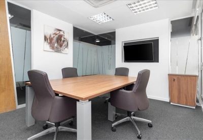 Conference room with a wooden table and four chairs.