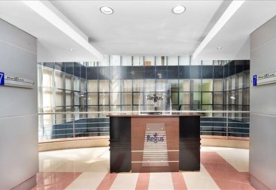 Branded reception desk area with a glass-walled background and warm lighting.