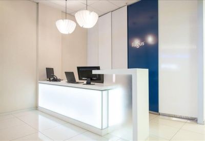 Modern white reception desk with integrated lighting and blue accent wall panel.