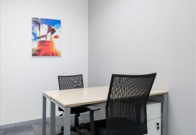 Compact private office with a two-person desk and golf-themed wall art.