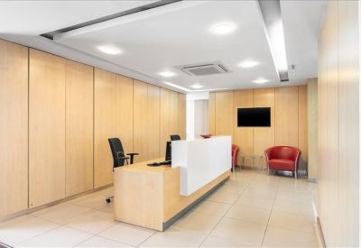 Modern reception area with a minimalist white desk and wood-paneled walls.