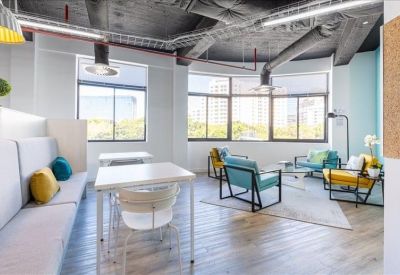 Modern coworking space with individual workstations and a long shared table.
